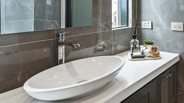 White bathroom sink on laminate countertop.