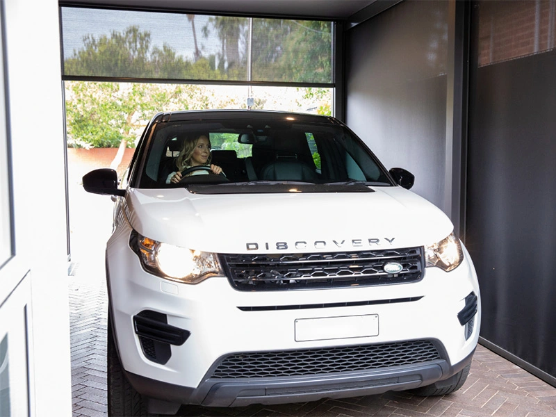 A white car parked inside a spacious garage