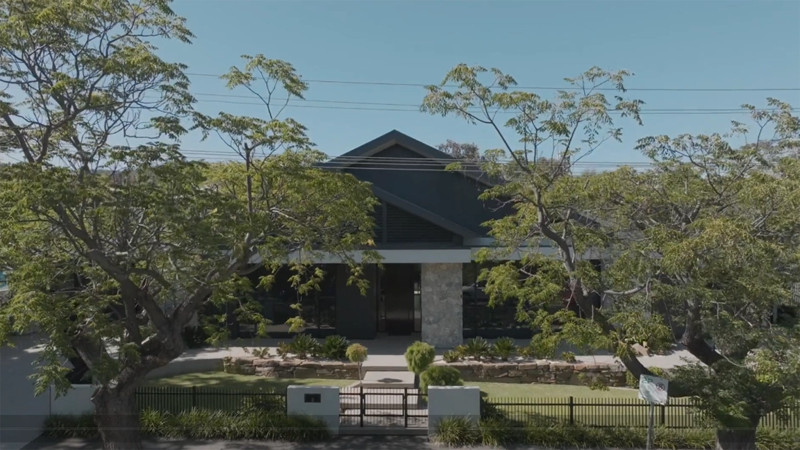 A house with a fence and trees in front of it