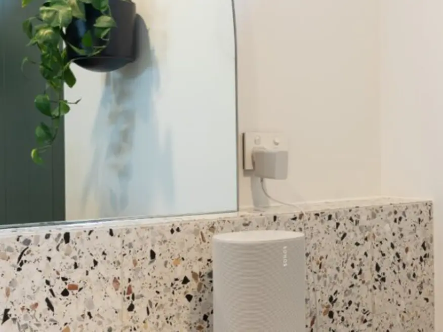 White bathroom mirror with built-in speaker.