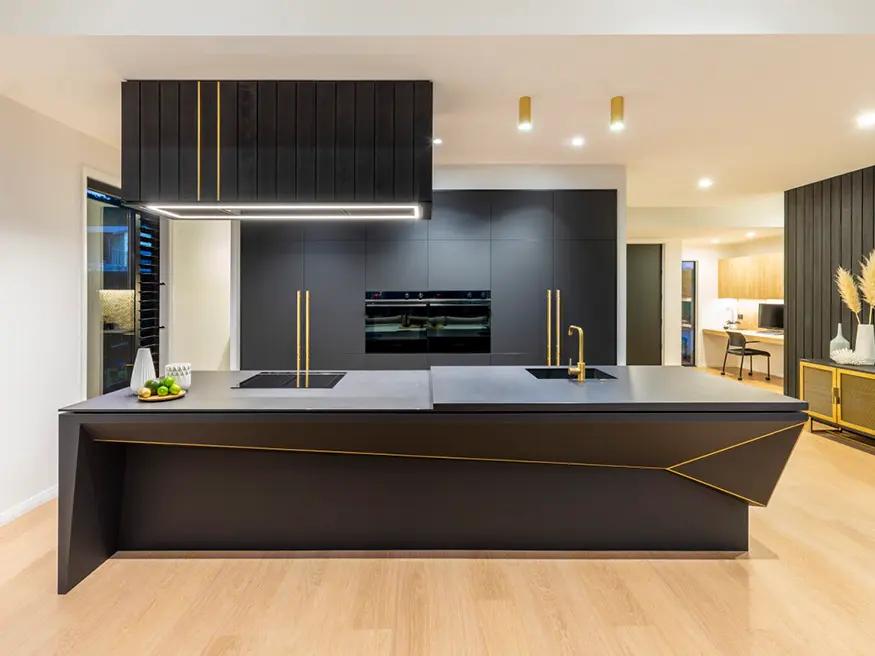 Modern kitchen with a large center island, stainless steel appliances, and light wood cabinets.