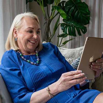 Woman seated on a couch, using an iPad