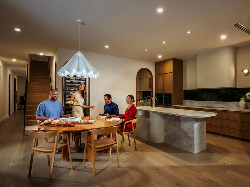 A family gathers around a kitchen table enjoying their food