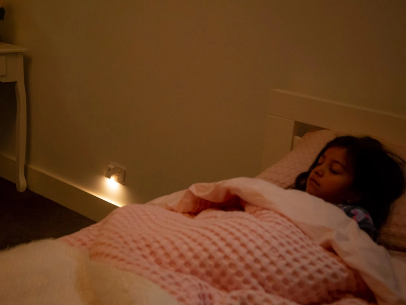 Little girl sleeping in bed, covered with soft pink blanket