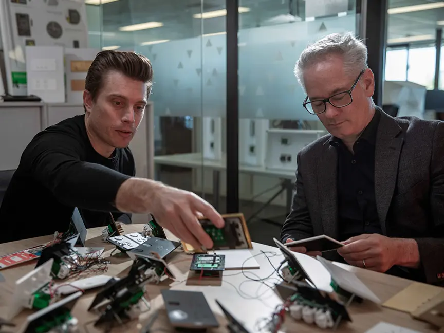 Tim Turrini-Rochford and Jim Hannon-Tan sitting at a table with electronics.