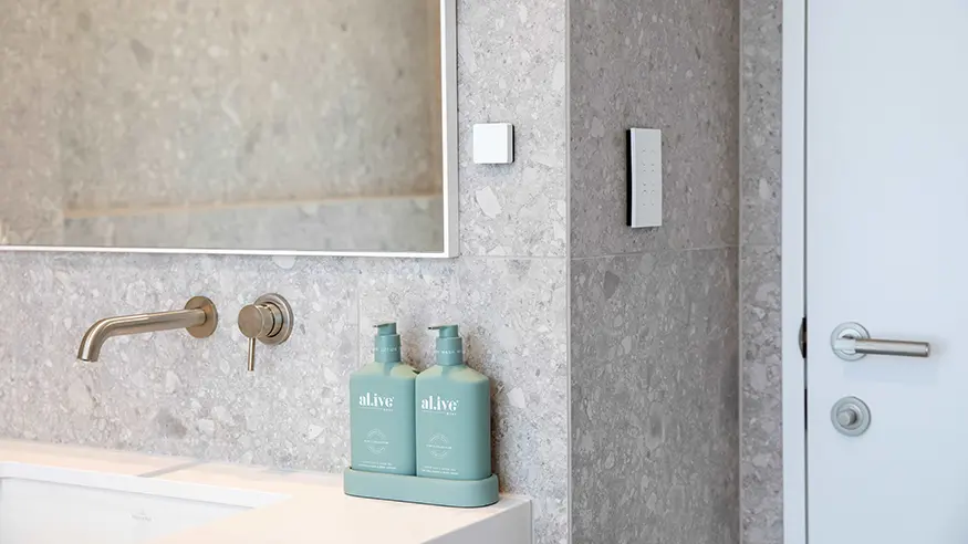 Bathroom sink with a mirror and soap bottles.