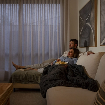 Couple watching a movie and eating a popcorn in the living room