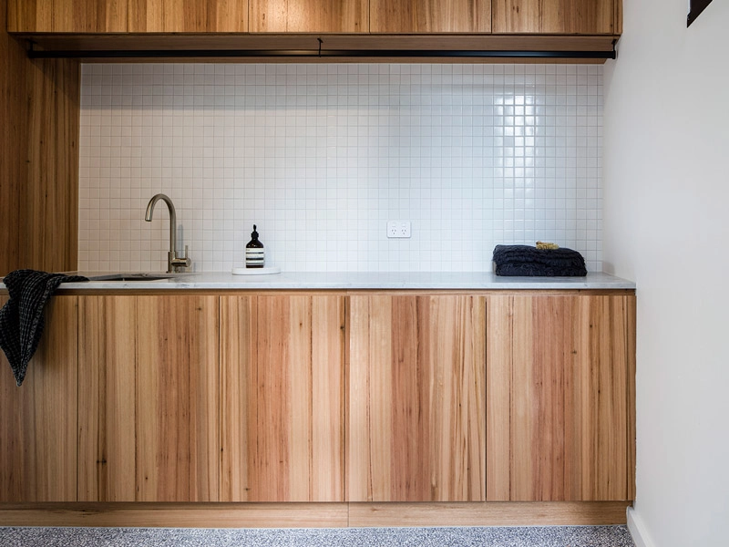 A cozy kitchen with wooden cabinets and a sink, highlighting a rustic and functional design