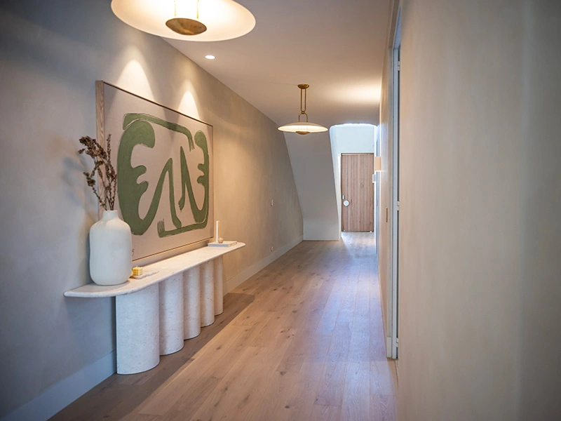 Cozy hallway featuring a painting on the wall and a decorative vase on a table