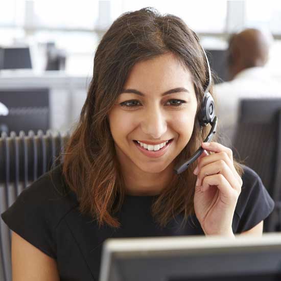 A woman with a headset in an office setting, focused on her work and communicating effectively.