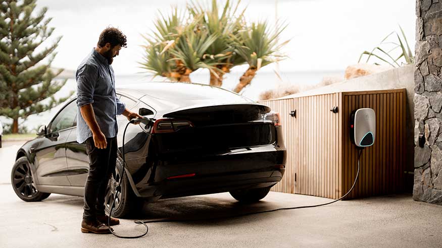 Man charging his electric vehicle with EVlink Home charger