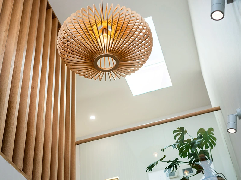 Stylish wooden hanging light fixture illuminates a cozy hallway