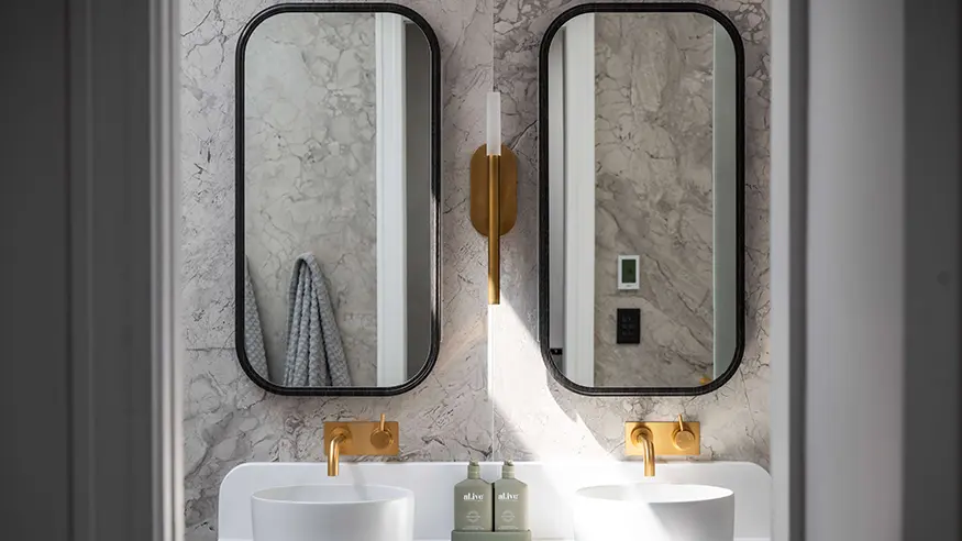 Bathroom vanity with two vessel sinks and round mirrors.