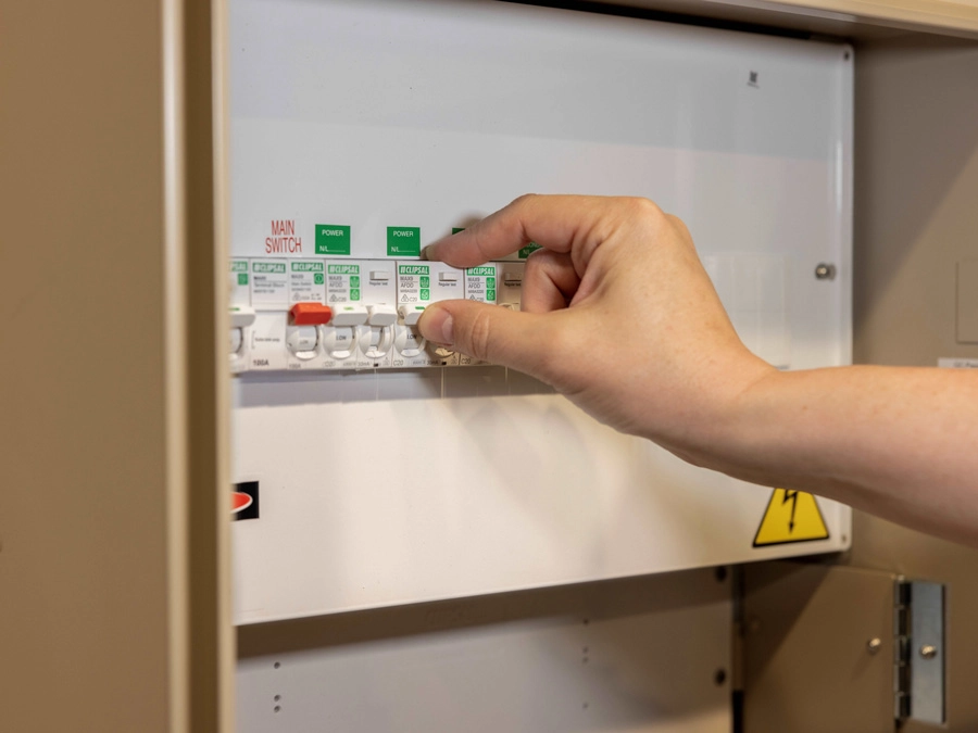 A hand touching a switchboard