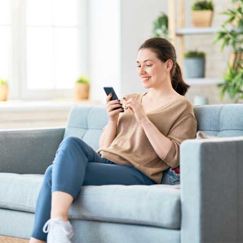 A woman on Phone using Clipsal by Schneider Electric’s Bluetooth Low Energy solution that works with the Iconic Switches.