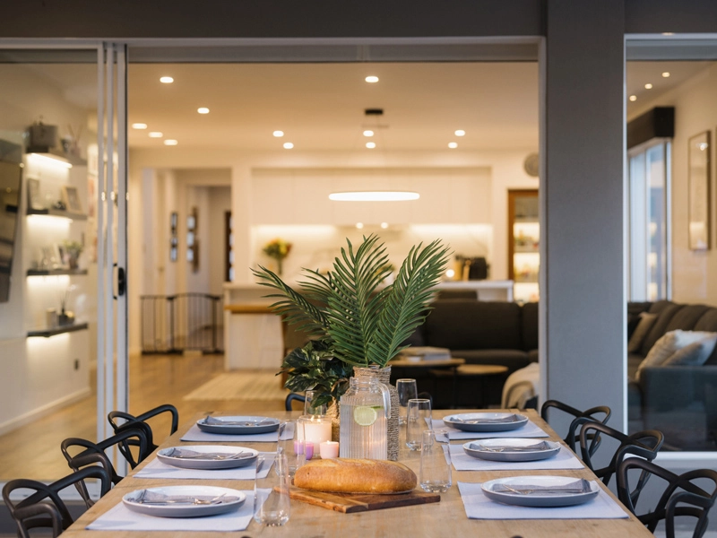 A dining room table set outside a modern house