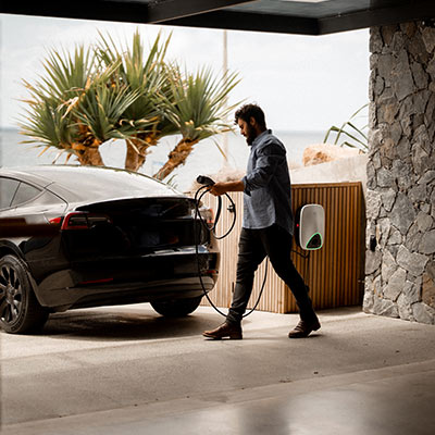 Man holding the wire of an EV charger preparing to charge his electric car