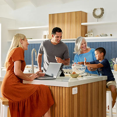 Family in kitchen with laptop