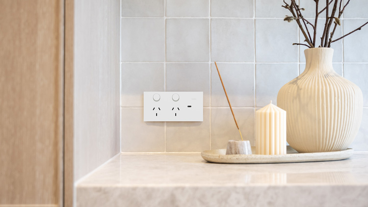 Modern kitchen counter with Solis matte white power socket on a tiled wall, next to decorative items