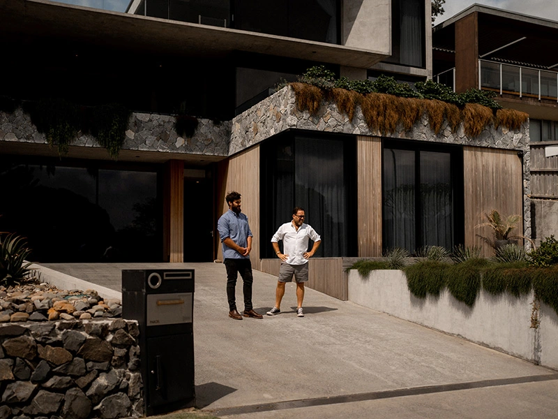 Two men standing outside a contemporary house