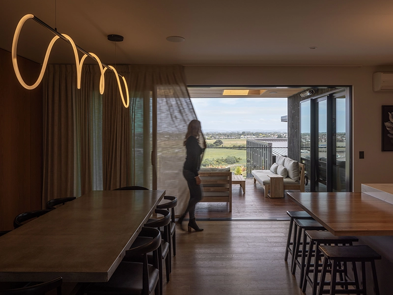 Woman opening the curtain to see the outdoor view