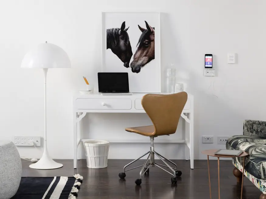 Home office with desk and framed pictures of horses.