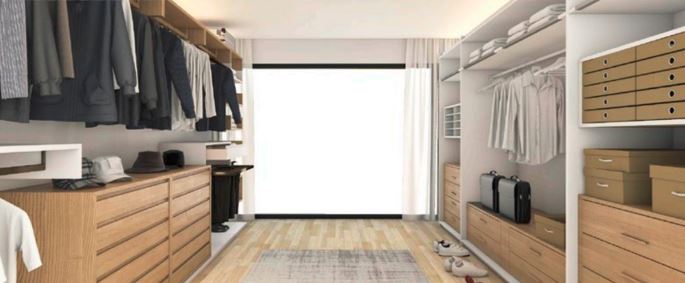 A stylish motion sensor walk-in closet with wooden shelving displaying an array of clothing for a well-organized appearance.